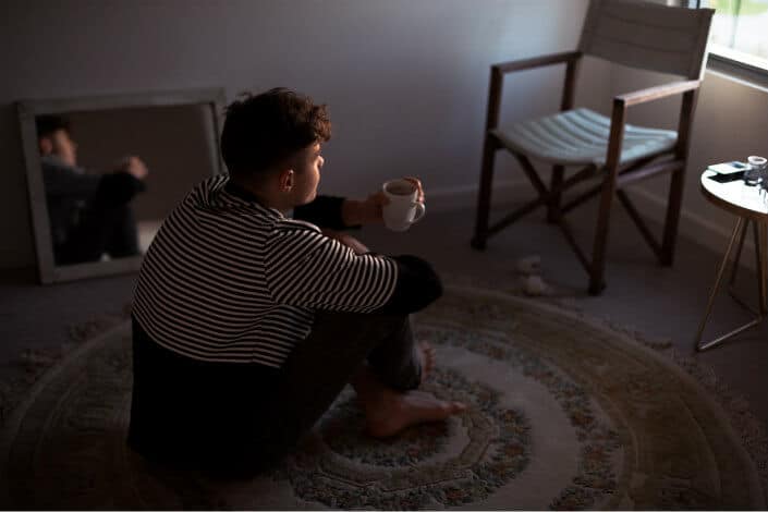 man sitting on rug looking nowhere