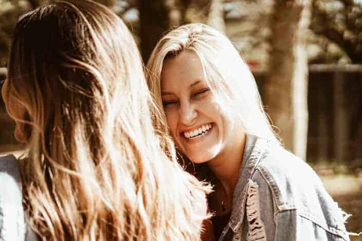 A girl laughing while talking to her mom.