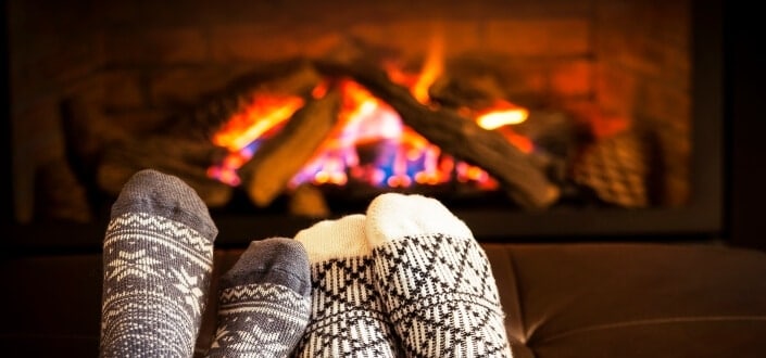 man chilling beside a fireplace