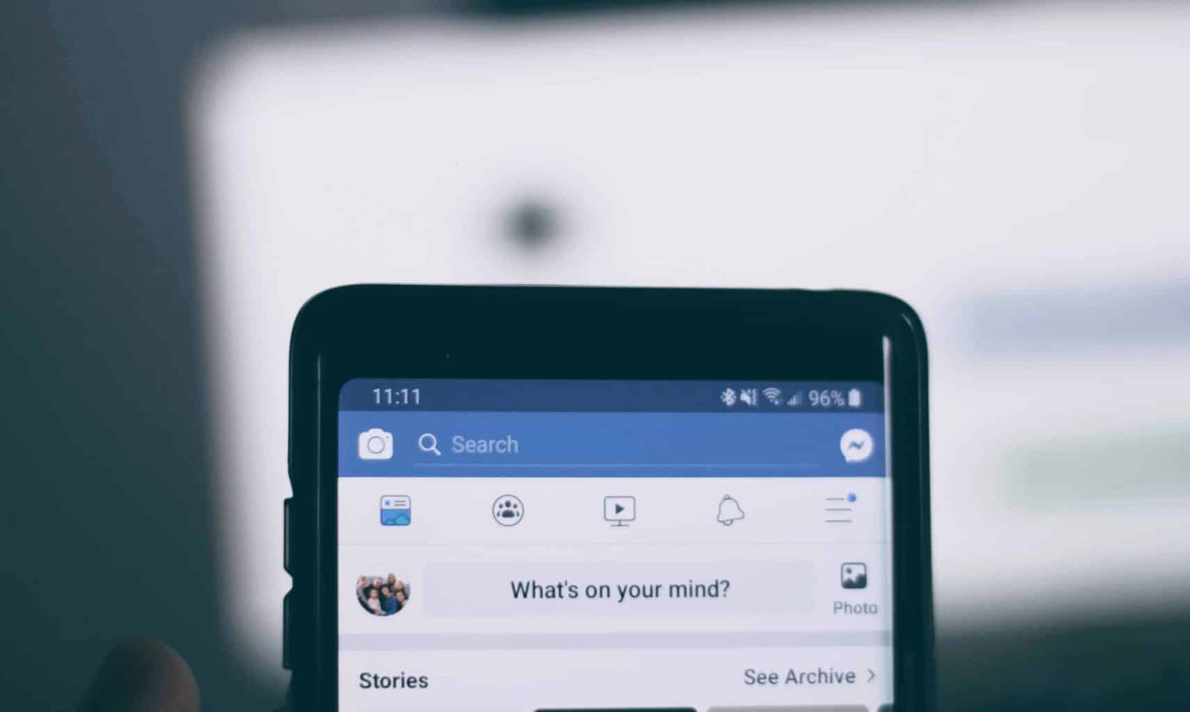 person holding phone using facebook account