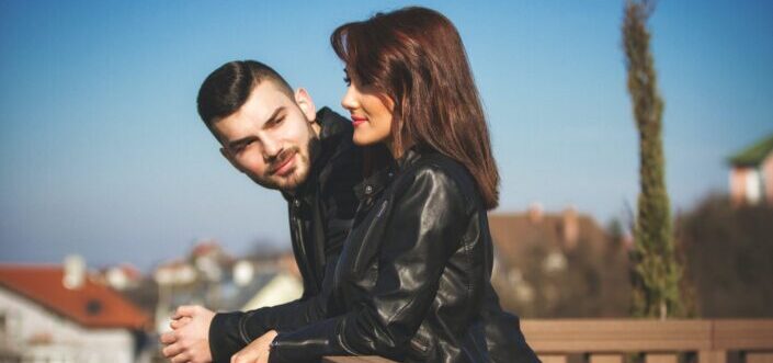 Man staring at his woman while sight seeing from a terrace.