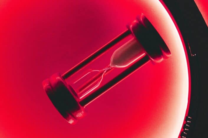 clear hour glass with red background