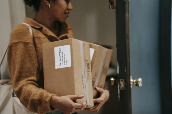 A woman carrying her parcel on the way inside her house