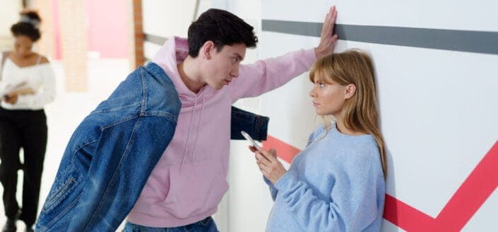 Guy wearing pink hoodie confronting a girl