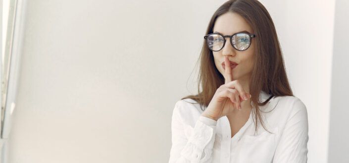 Flirty young lady asking to keep secret sitting in office