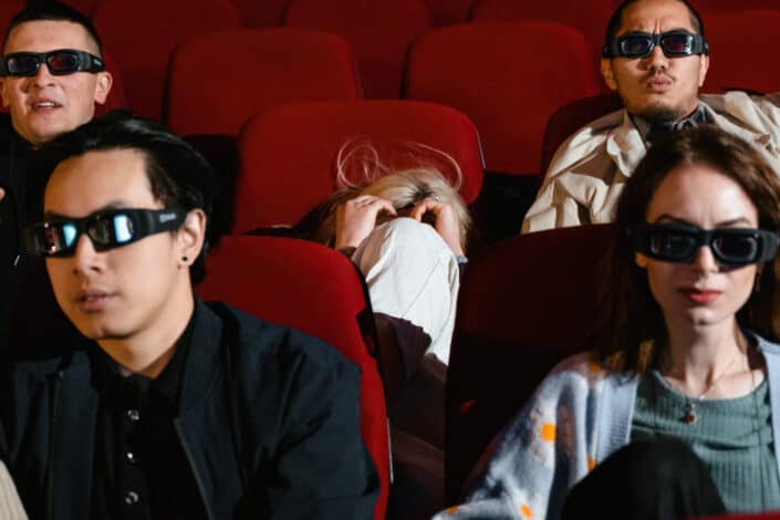 Woman hiding from her seat in the cinema