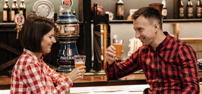 A man and a woman holding glasses with beer