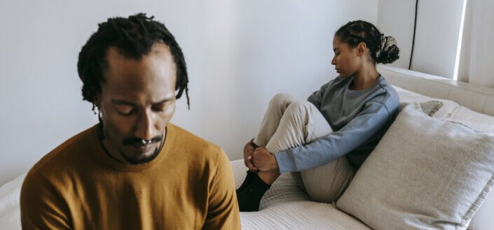 Couple on a bedroom looking sad