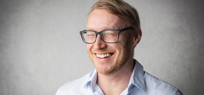 Guy wearing eyeglasses laughing hard