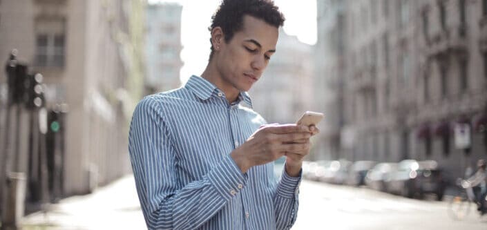 guy seriously surfing smartphone on street