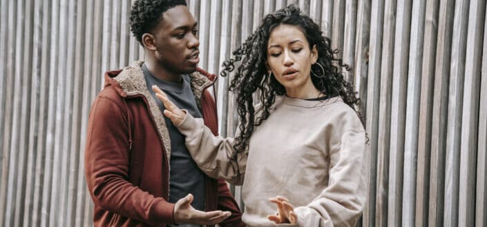 Frustrated multiethnic couple having arguement on street