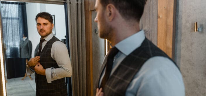 Man in a suit looking at his reflection