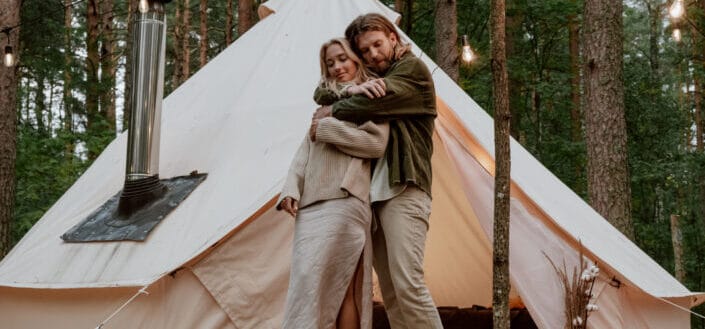 couple hugging near a white tent