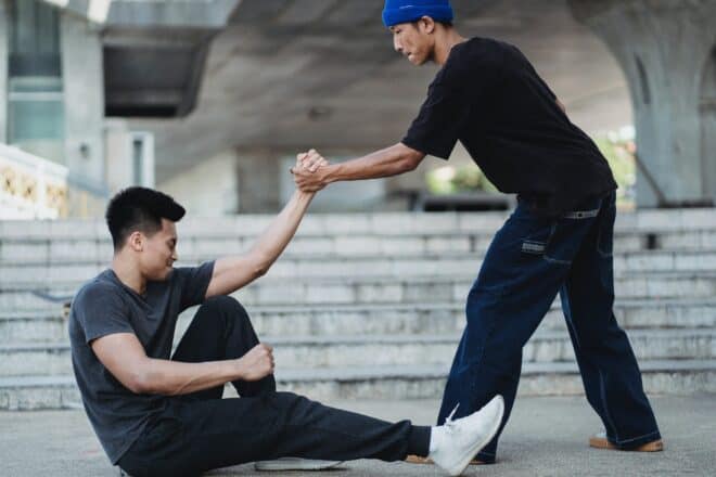 Man Helping Friend to Get Up