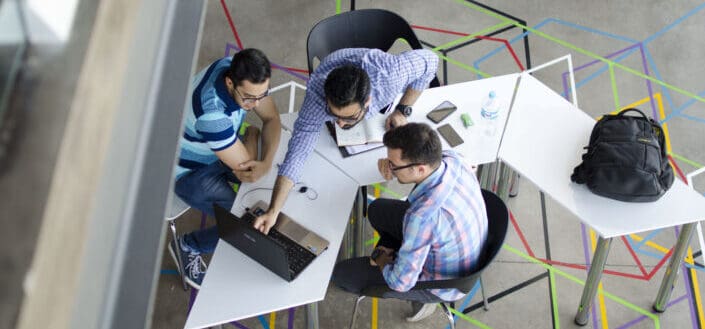 Three Men in Front of Laptop