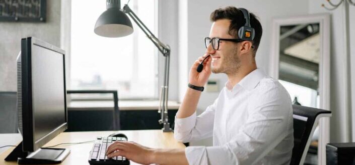 Man Wearing a Headset While Using Laptop