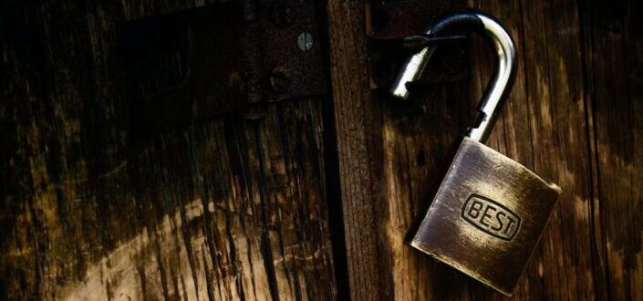 Gold Padlock on Brown Wooden Surface