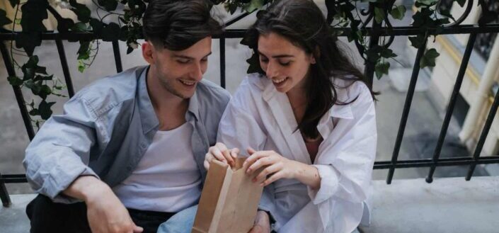 Man and Woman Holding Brown Paper Bag