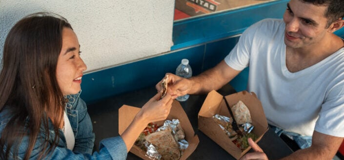 Couple Eating Takeout Sitting at The Table