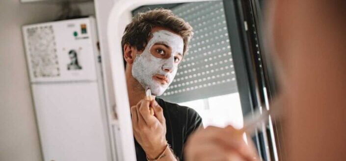 Man Looking at a Mirror Putting Face Paint