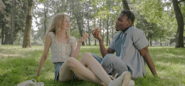Young Couple Sitting on Grass in Park