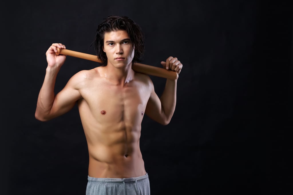 Young Asian man with clean-shaven chest holding a bat.