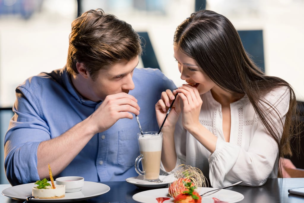 A couple enjoying a food and drink date together at a restaurant.