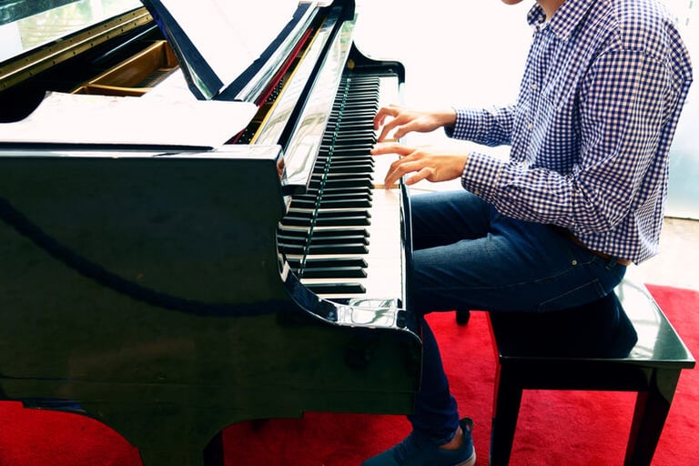 A man is playing a piano in his living room