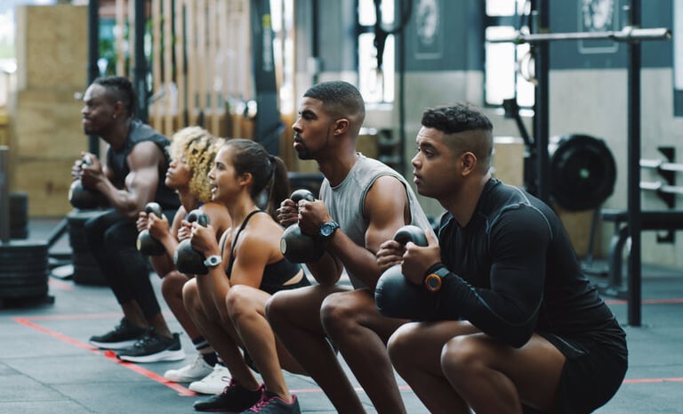 A Group of gym friends performing squats together
