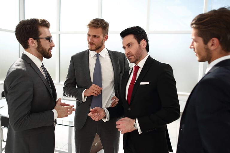 Men in professional attire are networking and discussing ideas during a successful men's networking night.