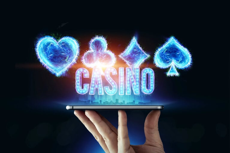 A man holding a smartphone with lights on the holographic card suits and the word CASINO