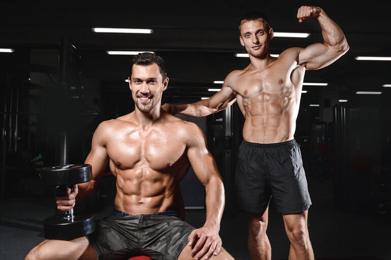 Two muscular men training in a gym representing mad muscles vs free workout plans.