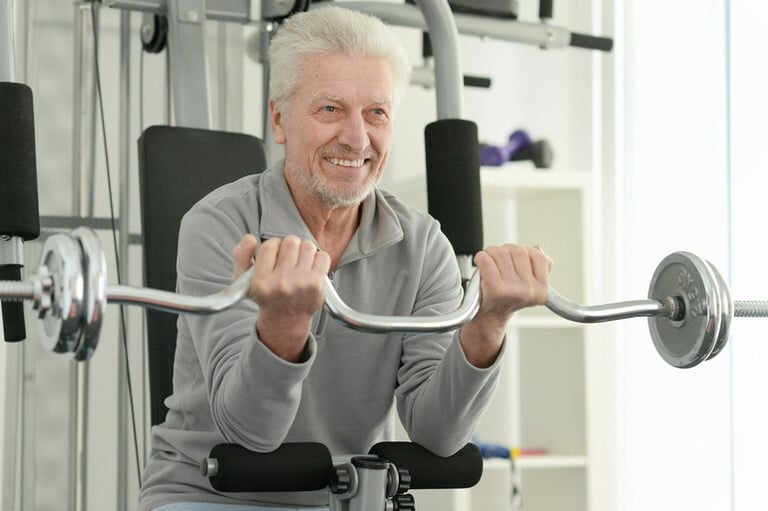 Older man exercising with weights as part of a fitness routine after asbestos exposure