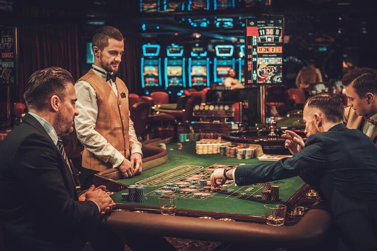 Men dressed in tailored suits playing roulette at an upscale casino, showcasing classic and smart men’s style for a casino night out