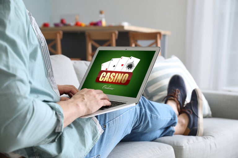 Young man with a laptop playing in a casino online at home