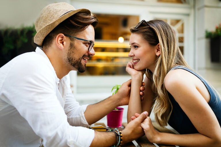 A man and a woman sitting at a table talking, highlighting common early dating communication mistakes and relationship dynamics