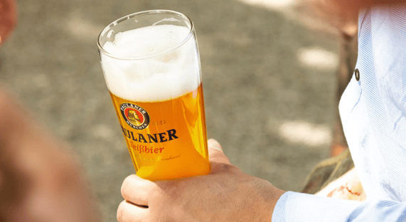 Hand holdig glass of Paulaner beer