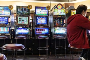 A person playing slot games on a digital screen, showing colorful reels and a casino-style interface.