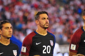 US men's national soccer team players standing in formation ahead of a match, illustrating an article on how the 2026 World Cup could impact the US economy.
