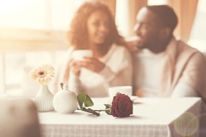 A couple enjoying a quiet, romantic moment together over coffee at home, illustrating how to keep romance alive in long-term relationships.