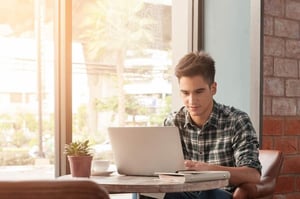 Man shopping for Harry Potter collectibles online using a laptop.