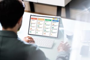 Person using a laptop and smartphone to develop, test, and market a mobile app, illustrating the process of building and selling apps as a profitable side hustle.