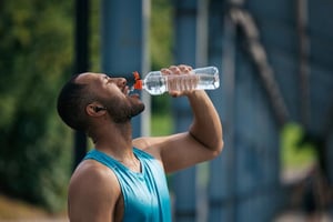 Endurance athlete drinking from a bottle during a long workout, highlighting the importance of hydration and fueling for sustained performance.