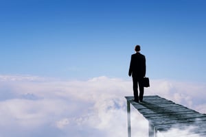Professional man standing on a path above the clouds, symbolizing purpose, responsibility, and professional growth.