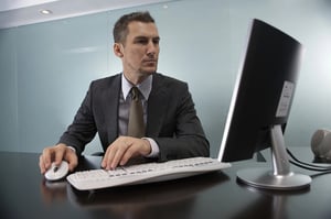 Man using a computer while researching the AmourFeel dating site before signing up.