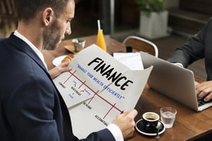 Man sitting on an office chair exploring a financial guide and chart about achieving financial independence.