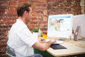 A man sitting on a chair and visiting the Asiavibe website on this laptop.