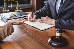 Lawyer documenting a lawful handover during a theft charge discussion at a legal desk.