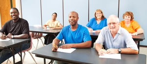 Five people sitting in a class in college.
