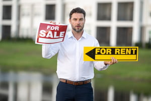 Landlord outside a rental property holding a “For Rent” pamphlet.